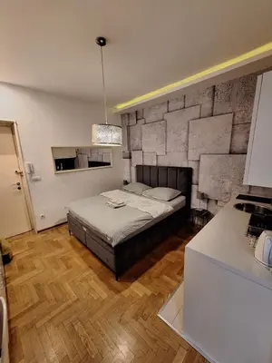 a bedroom with a bed with a stone wall at SQUARE M. in Belgrade