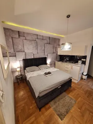 a bedroom with a large bed and a kitchen at SQUARE M. in Belgrade