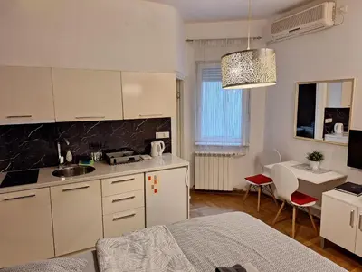 a kitchen with white cabinets and a sink in a room at SQUARE M. in Belgrade