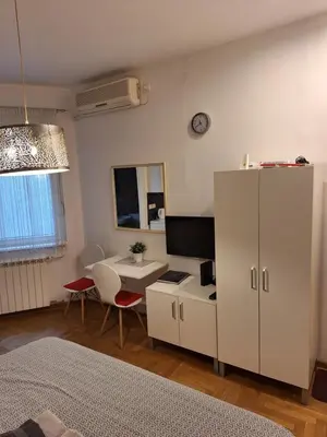 a room with a white cabinet and a table and a desk at SQUARE M. in Belgrade