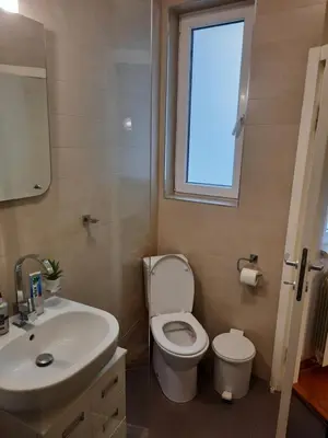 a bathroom with a toilet and a sink and a window at SQUARE M. in Belgrade