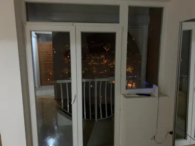 a sliding glass door with a view of a city at Simic Apartman in Arandjelovac