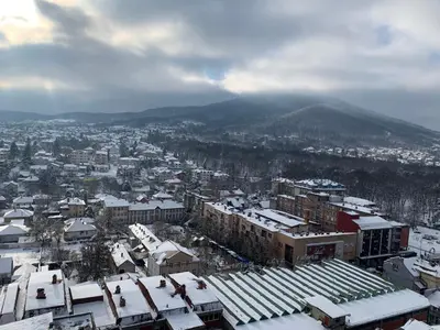 a city covered in snow with a mountain in the background at Simic Apartman in Arandjelovac