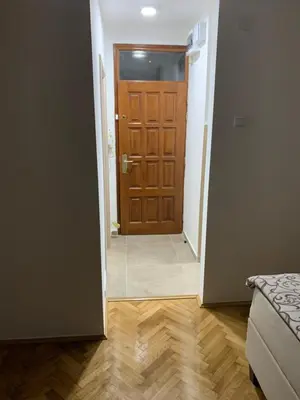 a hallway with a brown door and a wooden floor at Simic Apartman in Arandjelovac