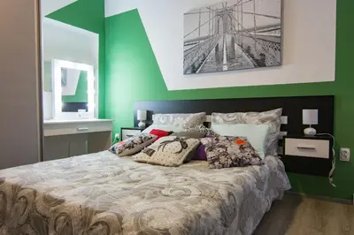 a green bedroom with a large bed with pillows at Filip in Belgrade