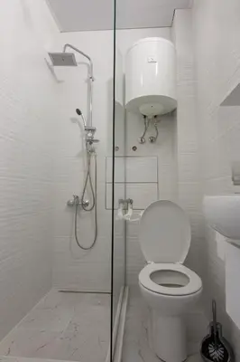 a white bathroom with a toilet and a shower at Filip in Belgrade