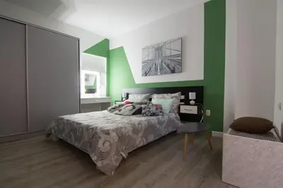 a bedroom with a bed and a green wall at Filip in Belgrade
