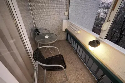 a small room with a table and a chair and a window at Apartman Lido in Belgrade