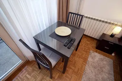 a black table with a remote control and a plate on it at Apartman Lido in Belgrade