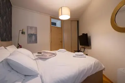 a bedroom with a white bed with towels on it at La Maison Panoramique Belgrade in Belgrade