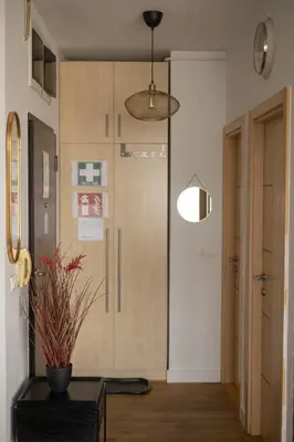 a hallway with a door with a potted plant on a table at La Maison Panoramique Belgrade in Belgrade