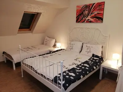 two twin beds in a room with a painting on the wall at Retro apartment in Zemun