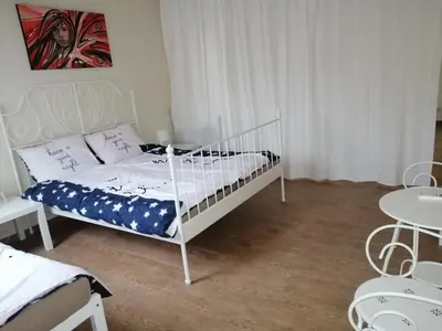 a bedroom with a white bed and a table at Retro apartment in Zemun