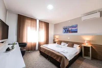 a hotel room with a bed and a television at River Inn in Stari Banovci