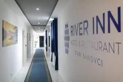 a hallway in a building with a sign on the wall at River Inn in Stari Banovci
