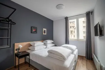 a bedroom with a bed with white sheets and a window at HostGost Selected Suites - Botanical Garden in Belgrade