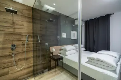 a bathroom with two beds and a shower at HostGost Selected Suites - Botanical Garden in Belgrade