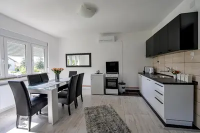 a kitchen with a table and chairs in a kitchen at Apartman DORA in Arandjelovac