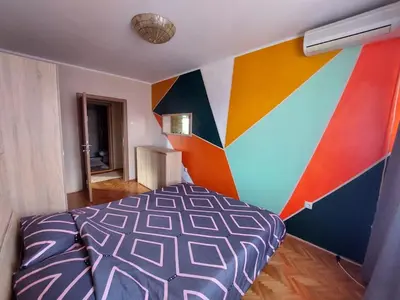 a bedroom with a colorful wall with a bed at Lagumska in Zemun