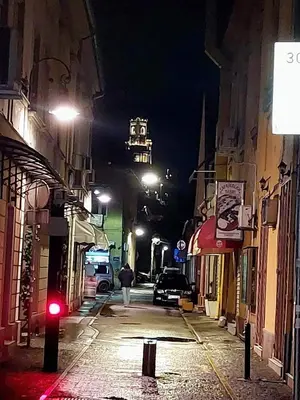 a person walking down a street at night at Lagumska in Zemun