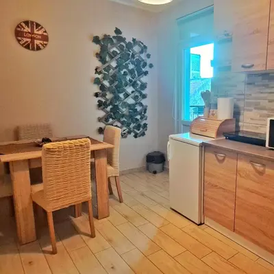 a kitchen with a wooden table and a table and chairs at Lagumska in Zemun