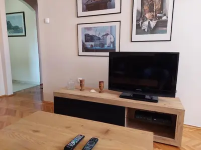a living room with a television and two remote controls at Lagumska in Zemun