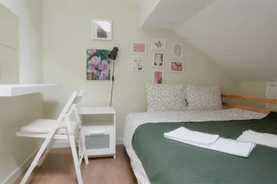 a small bedroom with a bed and a ladder at VUKAJLO apartment Belgrade in Belgrade