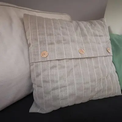 a pillow with buttons on it sitting on a bed at VUKAJLO apartment Belgrade in Belgrade