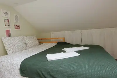 a green bed with two white towels on it at VUKAJLO apartment Belgrade in Belgrade