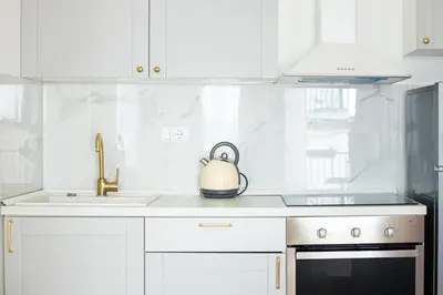 a kitchen with white cabinets and a tea kettle on the counter at Etoile City Center Apartments- Obilicev venac in Belgrade