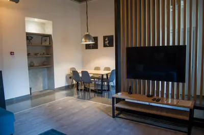 a living room with a television and a table with chairs at K43 Apartment in Belgrade