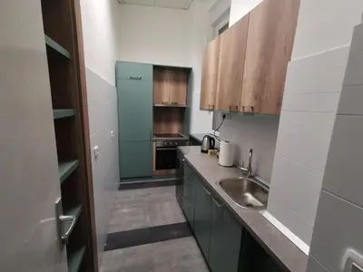a kitchen with green cabinets and a sink and a counter at K43 Apartment in Belgrade