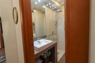 a bathroom with a sink and a shower and a mirror at BelArt apartment in Belgrade