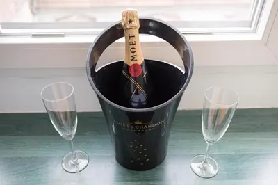 a bottle of wine in a bucket with two wine glasses at BelArt apartment in Belgrade