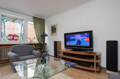 a living room with a television and a chair at BelArt apartment in Belgrade