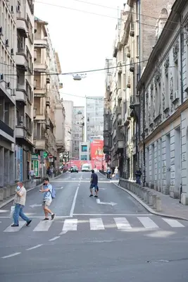 a group of people crossing a street in a city at BelArt apartment in Belgrade