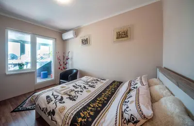 a bedroom with a bed and a chair and a window at Apartment Africa in Belgrade