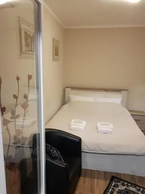 a small bedroom with a bed and a chair at Apartment Africa in Belgrade