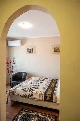 a bedroom with a bed and a black chair at Apartment Africa in Belgrade