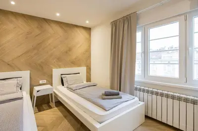 a bedroom with a white bed and a wooden wall at Belgrade Old Town Apartment in Belgrade