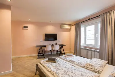 two beds in a room with a table and a desk at Belgrade Old Town Apartment in Belgrade