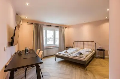 a bedroom with a bed and a table and a window at Belgrade Old Town Apartment in Belgrade