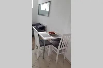 a white dining room table and chairs with a mirror at St. Marko studio in Belgrade