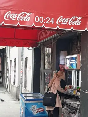 a woman standing in front of a cocacola shop at Studio Prim in Belgrade