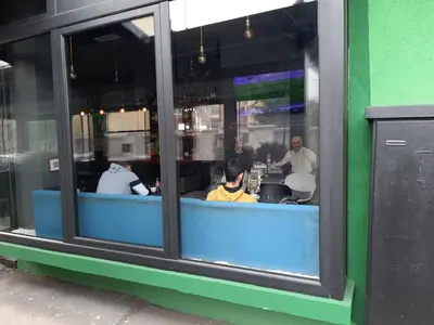 a group of people sitting at a table in a window at Studio Prim in Belgrade