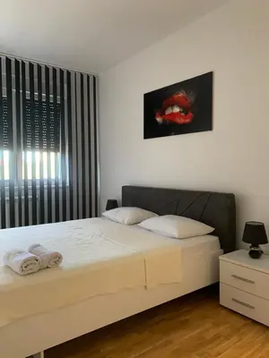 a bedroom with a bed and a painting on the wall at Royal Residence Apartmani in Pančevo