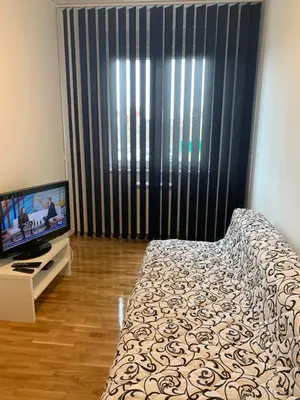 a bedroom with a bed and a flat screen tv at Royal Residence Apartmani in Pančevo
