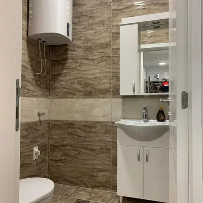a bathroom with a toilet and a sink and a mirror at Royal Residence Apartmani in Pančevo