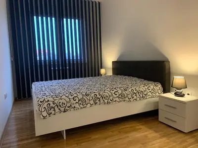 a bedroom with a bed and a large window at Royal Residence Apartmani in Pančevo