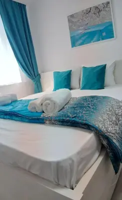 a large bed with a blue blanket on it at Sarajevska Studio & Apartment in Belgrade